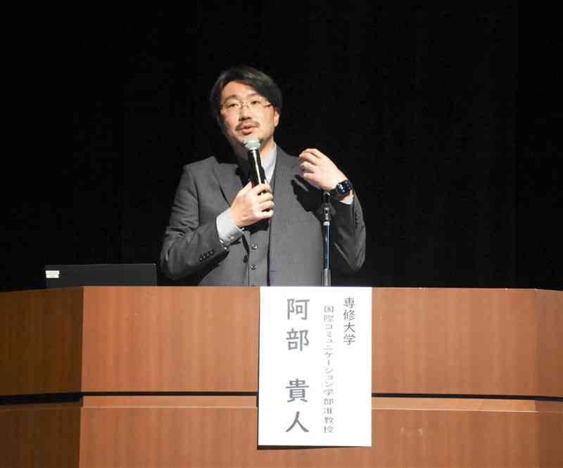 「やさしい日本語」を考えるフォーラムで講演する専修大の阿部貴人准教授＝7日、玉名市