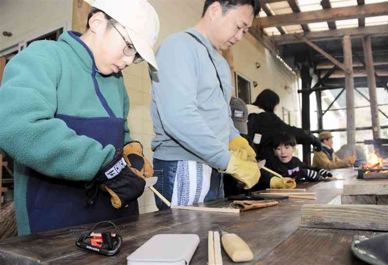 ナイフを使って、竹の箸作りに挑戦する参加者たち＝8日、球磨村