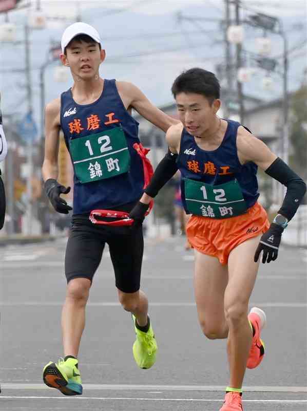 第2中継所、錦町Aの3区岡﨑致大（右）にトップでたすきを渡す2区福永大漣＝15日、多良木町（小野宏明）