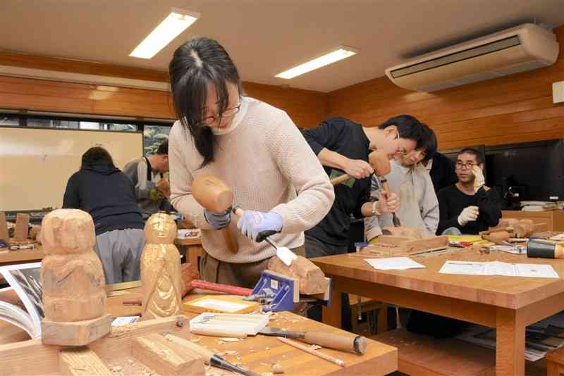 のみと木づちを使って仏像を彫る参加者ら＝14日、津奈木町