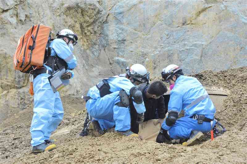 土砂崩れに巻き込まれた車から要救助者を助け出す訓練をする消防隊員ら＝17日、美里町