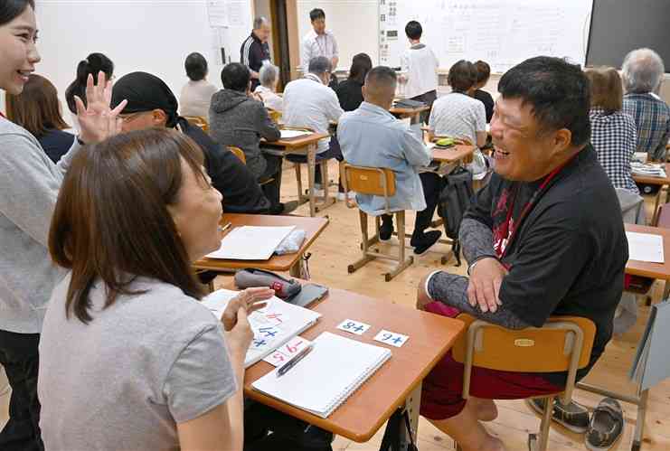 数学の授業でクラスメートと話しながら問題を解くゆうあい中1年の中山弘樹さん（右手前）＝5月、熊本市中央区（小野宏明）