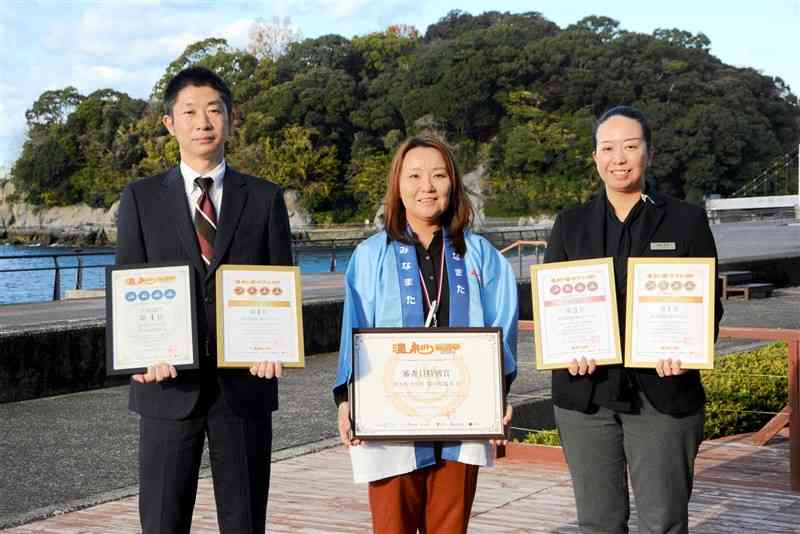 温泉総選挙の表彰を受けて「来年の開湯100年の機運醸成につなげたい」と話す湯の児温泉関係者ら＝19日、水俣市