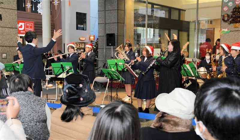 クリスマスソングなどを演奏する熊本農業高校の吹奏楽部＝22日、熊本市中央区