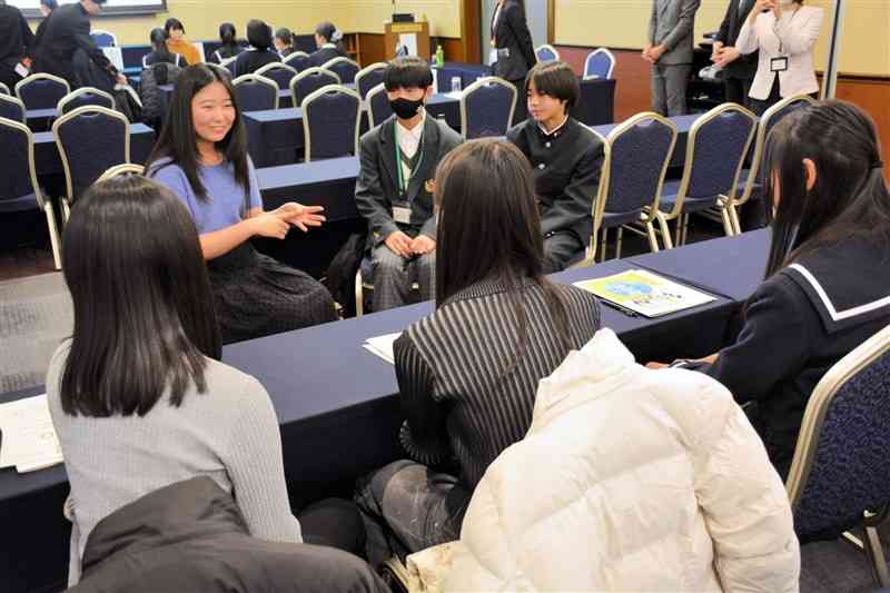 留学経験者（左奥）の話を聞く中高生＝22日、熊本市中央区