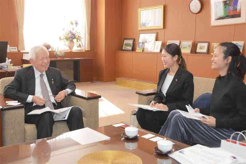 来夏に熊本で開かれる日米学生会議について、熊本日米協会の河村邦比児会長（左）に報告する実行委員会の北原真悠さん（右）と小川志穂さん＝23日、熊日本社