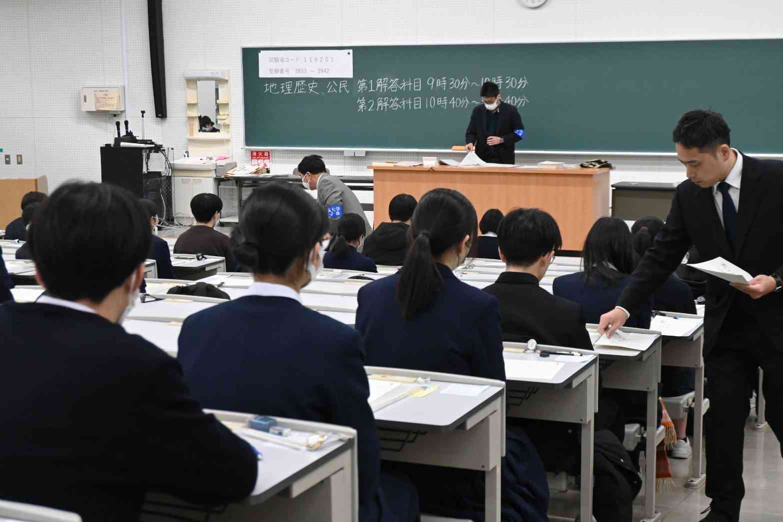 試験問題や解答用紙を受け取る大学入学共通テストの受験生＝18日午前9時10分ごろ、熊本市中央区の熊本大（谷川剛）