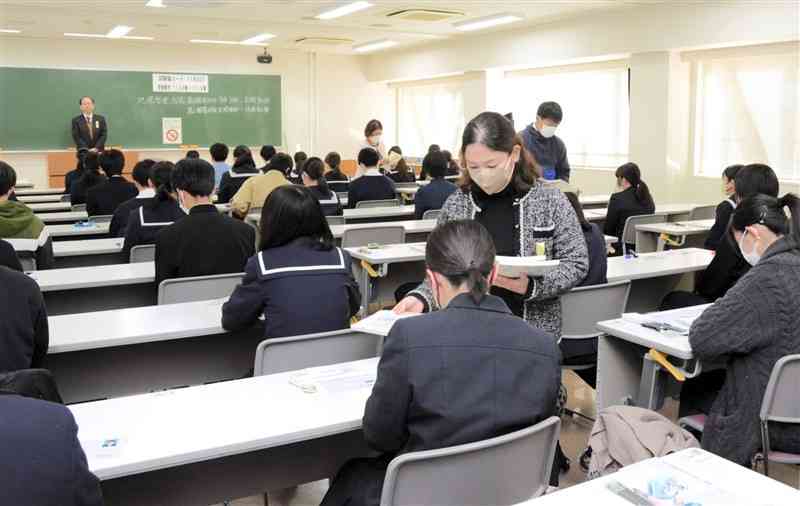 昨年の大学入学共通テストで試験問題や解答用紙を受け取る受験生＝2024年1月、熊本市中央区の熊本大黒髪キャンパス