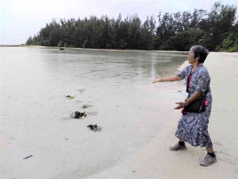 ペリリュー島の海に向かって献花する白濱アケミさん＝2024年9月（白濱さん提供）