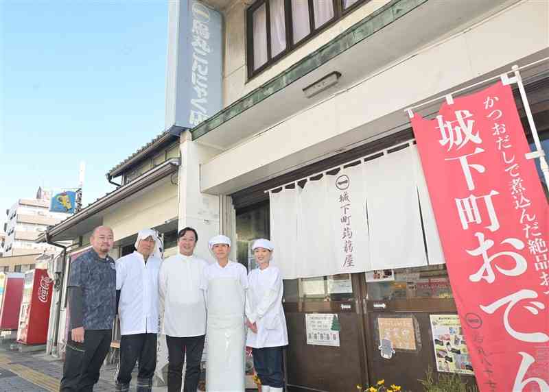 鳥丸八十七商店の前に立つ鳥丸克彦代表（中央）と従業員たち＝2024年12月、熊本市中央区（谷川剛）