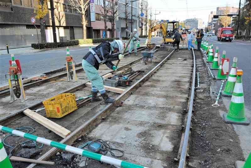 昨年末に起きた熊本市電の脱線事故の現場付近で、レールの補修工事をする作業員＝１月2日、熊本市中央区