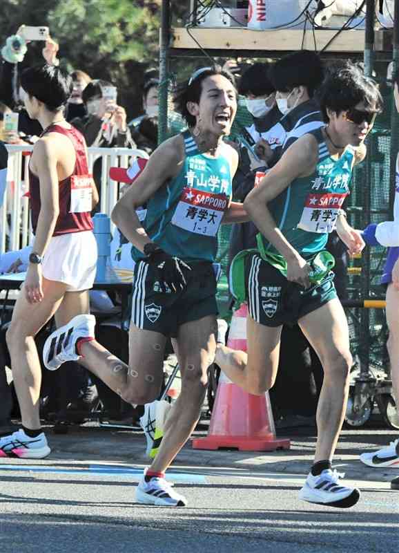 平塚中継所でたすきをつなぐ青学大の鶴川正也（左）＝2日、神奈川県平塚市