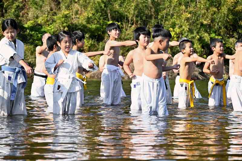 菊池川に入って空手の寒稽古をする子どもたち＝2日、山鹿市