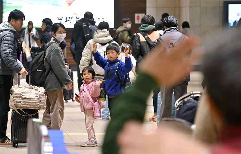 Uターンラッシュがピークを迎え、新幹線の改札口で別れを惜しむ家族連れ＝4日午前11時過ぎ、熊本市西区のJR熊本駅（上杉勇太）