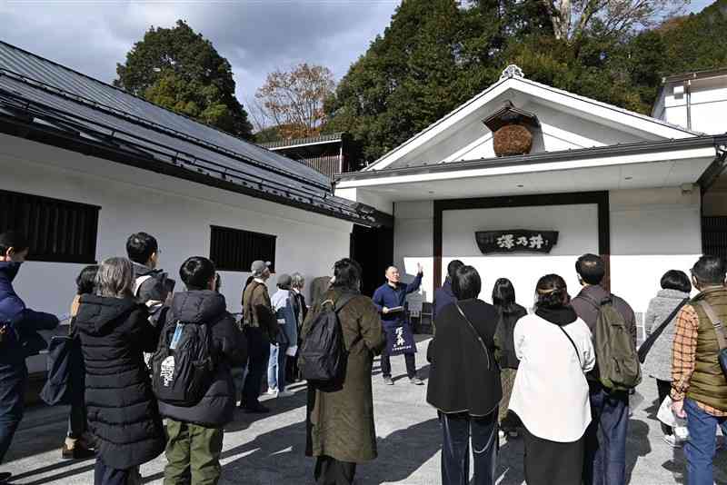 酒蔵の前に集まって説明を聞く観光客＝2024年12月、東京都青梅市