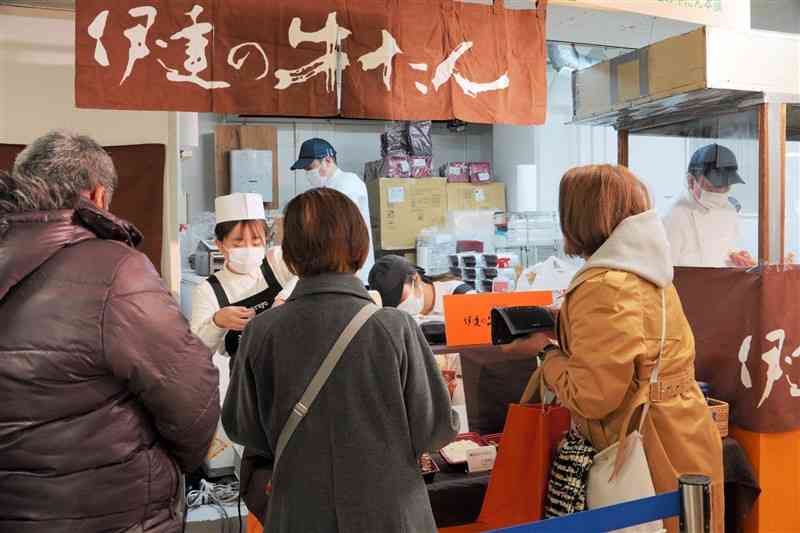 鶴屋百貨店で始まった「東北六県の物産と観光展」で牛タン弁当を購入する買い物客ら＝8日、熊本市中央区