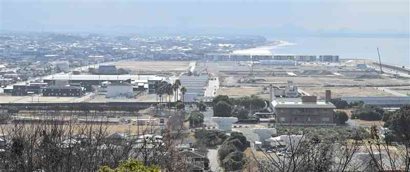 荒尾競馬場跡地を再開発して整備するあらお海陽スマートタウン（中央）。左手前がトライアル、右側には市ウェルネス拠点施設の工事現場が見える＝8日、荒尾市