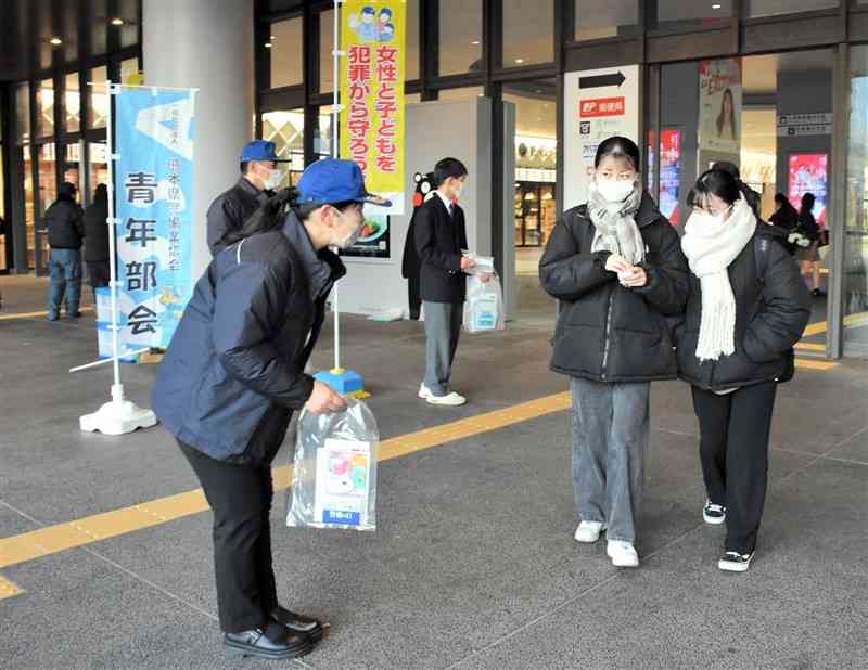 JR熊本駅で駅利用者にリーフレットを配って痴漢撲滅を呼びかける警察官ら（左）＝10日、熊本市西区