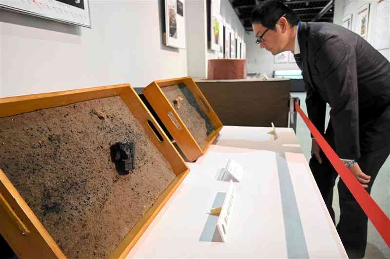 「遺跡発掘速報展」で展示している大江遺跡群の土層。黒い粒が炭化米＝10日、熊本市中央区