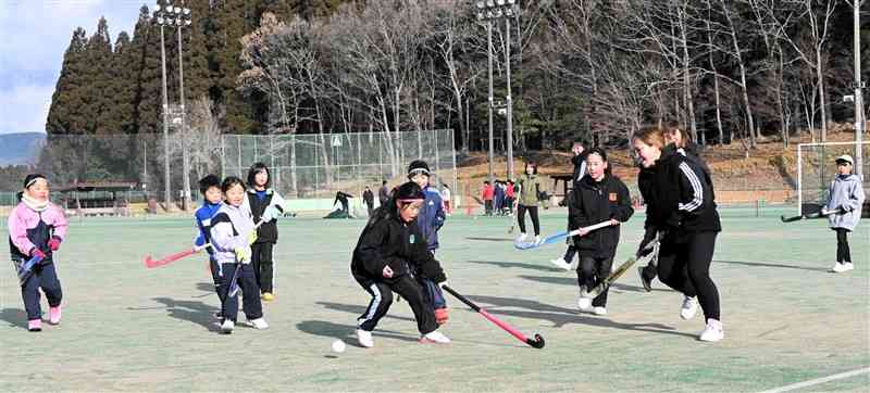 ホッケーの「初打ち会」で保護者と交流試合を楽しむ小学生＝11日、小国町