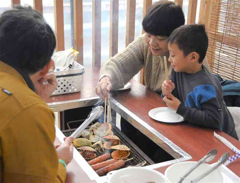 道の駅みなまたでカキを楽しむ家族連れ＝11日、水俣市