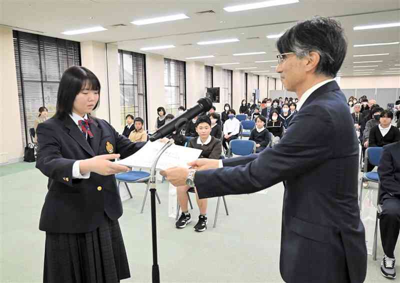 第78回熊日学童スケッチ展で熊日賞を受賞し、賞状を贈られる長嶺中2年の濱川月紫さん（左）＝12日、熊本市中央区