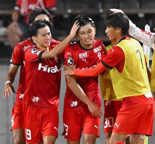 第33節群馬戦。後半終了間際に勝ち越しゴールを決め、味方からの祝福を受ける熊本のDF岩下（中央）＝前橋市の正田醤油スタジアム群馬