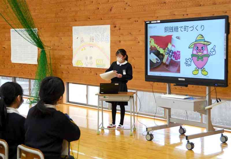 町のキャラクター、からいもくんをお菓子のパッケージデザインに使うアイデアを披露する児童＝14日、大津町