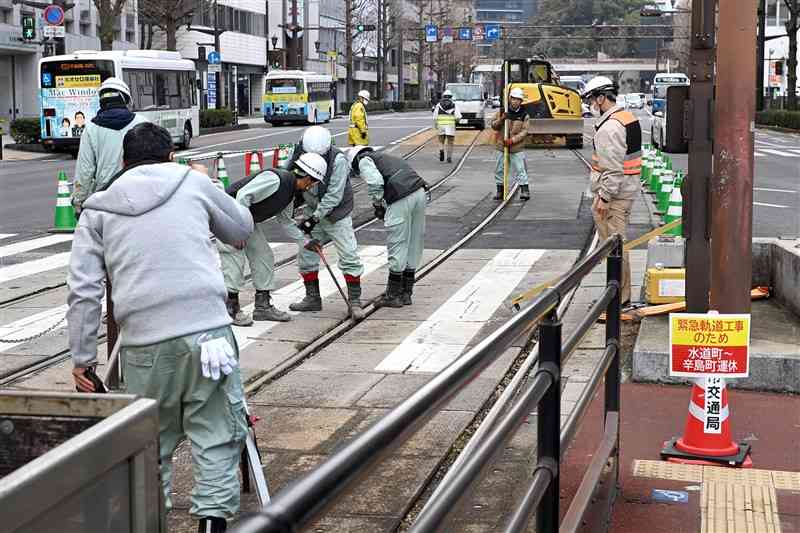 熊本市電の熊本城・市役所前電停付近で、緊急の工事をする作業員＝15日正午ごろ、熊本市中央区（上杉勇太）