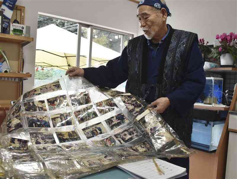 阪神大震災の炊き出し活動について当時の写真を手に語る濱田龍郎さん＝益城町