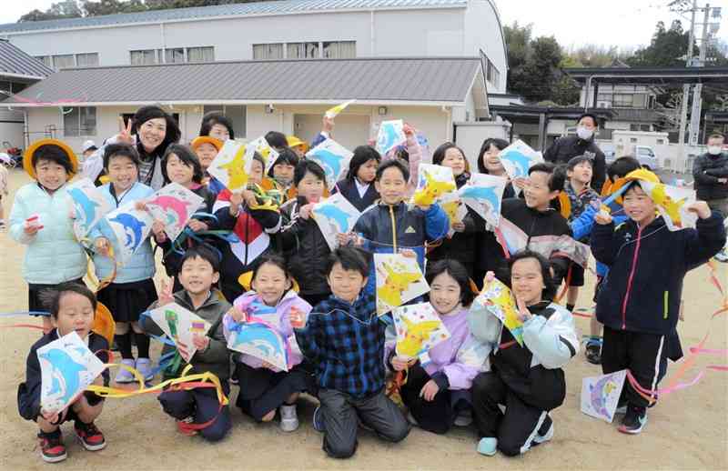 作ったばかりの凧を手に持つ児童たち＝16日、天草市