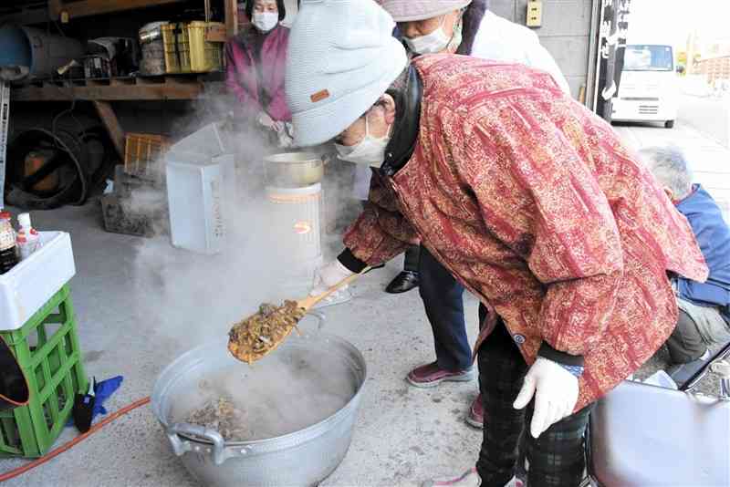 シシ肉を煮込む滑石上区の住民ら＝17日、玉名市