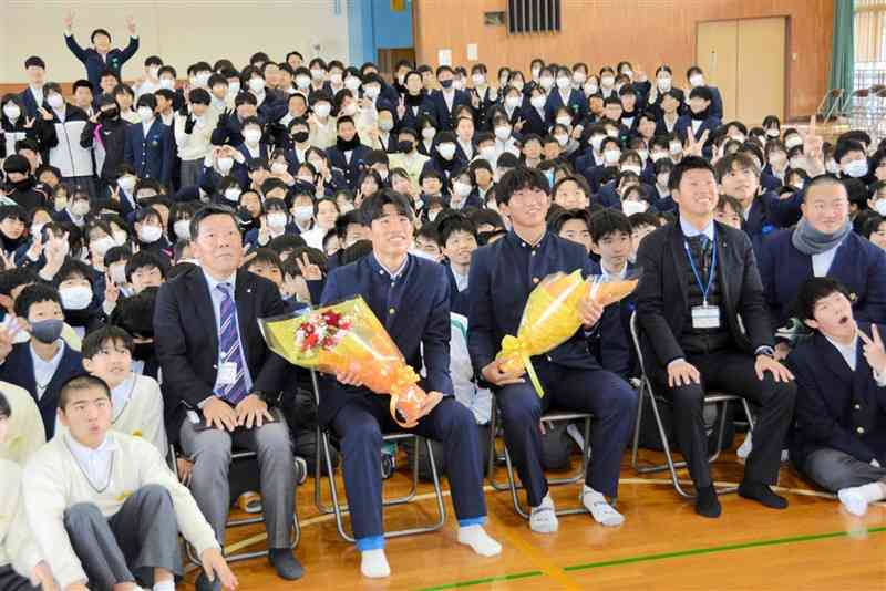 大津中生徒と記念撮影する大津高サッカー部の五嶋夏生主将（前列中央右）と山下景司選手（同左）＝17日、大津町