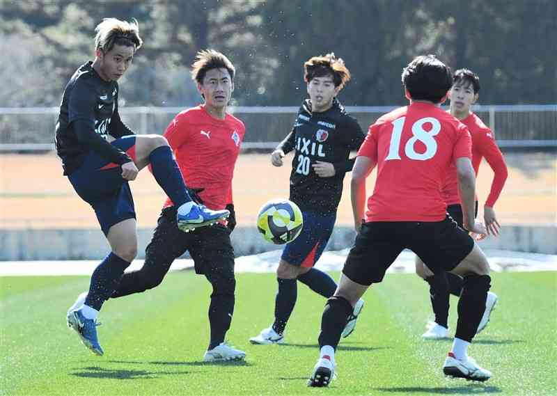 熊本との練習試合で味方にパスを出す鹿島のMF荒木（左）＝宮崎・ひなた陸上競技場