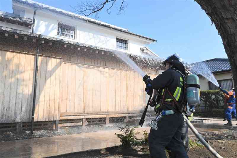 消防訓練で四時軒に放水する消防署員ら＝22日、熊本市東区