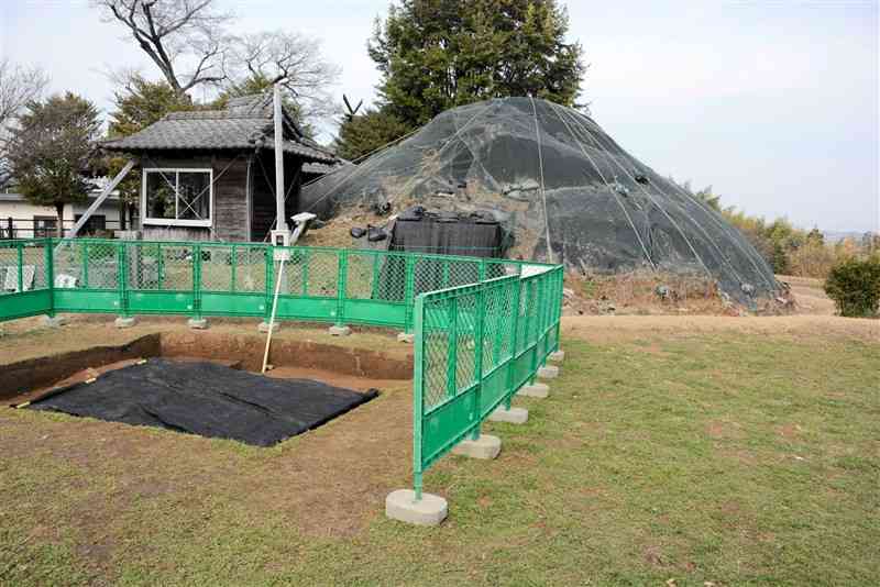 熊本地震で墳丘が崩れ、シートに覆われた釜尾古墳。手前の発掘調査地からは墓道などが確認された＝24日、熊本市北区