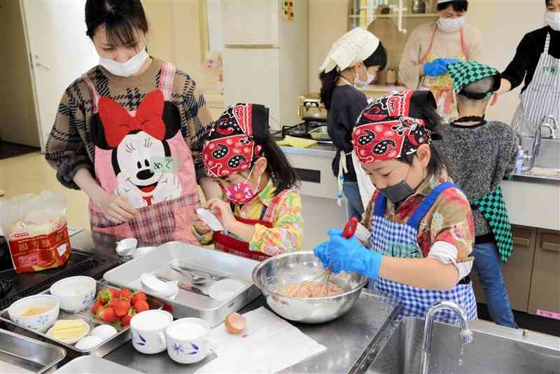 イチゴの蒸しケーキを作る子どもたち＝26日、熊本市南区