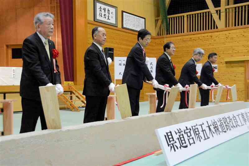 熊本県による県道宮原五木線改良工事の着工式で、工事の無事を願ってくわ入れする関係者＝26日、五木村