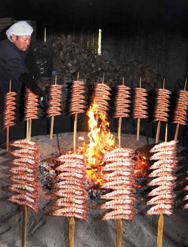 大きないろりで焼かれる「つるし焼きエビ」＝27日、芦北町