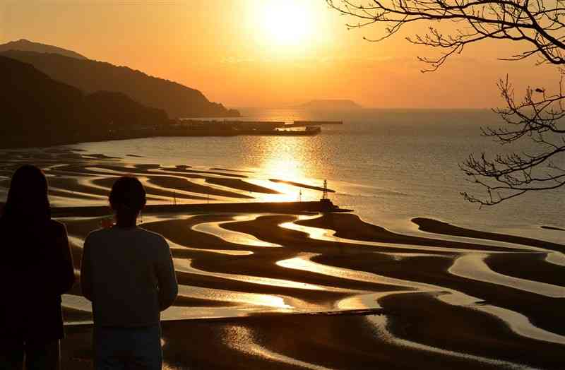 干潟に現れた砂紋と夕日によって幻想的な光景が広がる御輿来海岸＝30日、宇土市