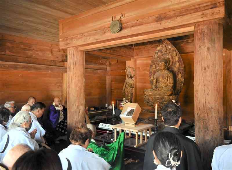 城泉寺であった「三日月詣」で繊月石の前で祈りを捧げる参拝客ら＝1月31日、湯前町