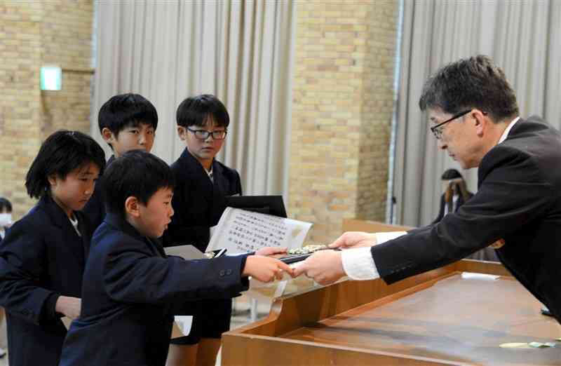 「くまもとの笑顔・未来を創る児童生徒表彰式」で白石伸一教育長（右）から表彰状を受け取る児童＝4日、熊本県庁