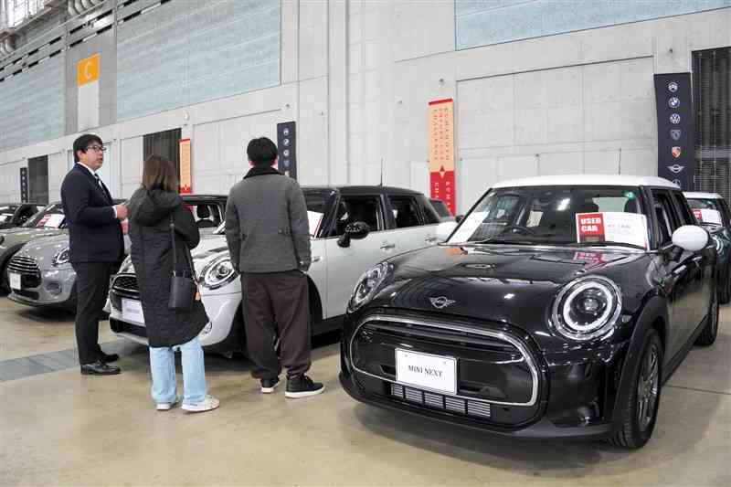 展示された輸入車を見る来場客ら＝8日、益城町