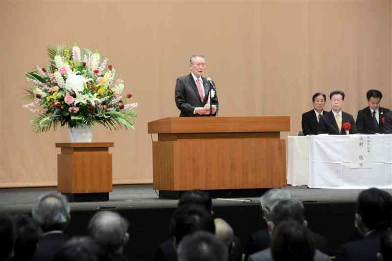 芦北町の合併20周年記念式典であいさつする竹﨑一成町長＝8日、同町