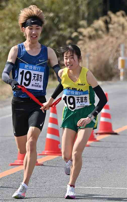 第11中継所、天草市の吉田大和（左、熊本YMCA学院）が吉原碧彩（千原台高）にたすきをつなぐ＝宇城市（上杉勇太）