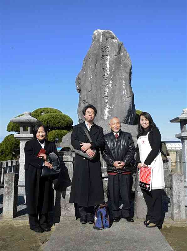 古城弥二郎墓前祭に参列した古城貴也さん（左から2人目）と郡築校区住民ら＝9日、八代市