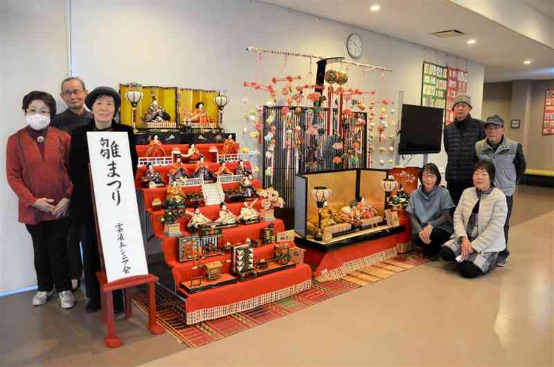 岱明町公民館にひな飾りを展示している「雲雀丘シニア会」のメンバー＝7日、玉名市