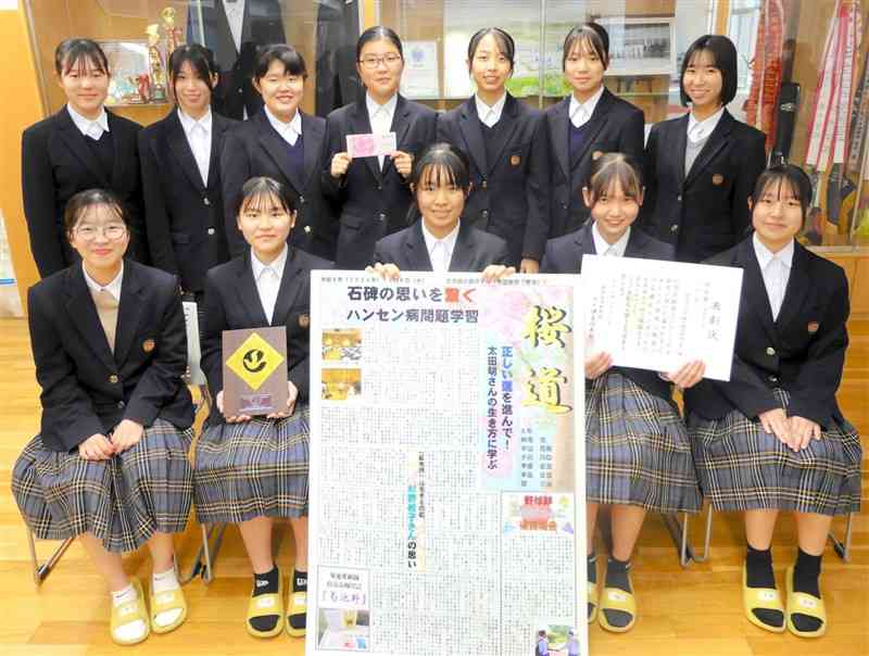 「熊日新聞コンクール中学新聞の部」でグランプリを受賞した作品を囲む合志楓の森中の生徒（同校提供）