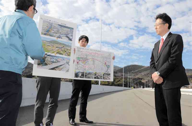 熊本西環状道路につながる池上ICの導入路で、工事の進捗状況などの説明を受ける大西一史市長＝13日、熊本市西区