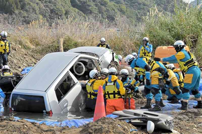 水没した車からの救助訓練を実施する九州管区広域緊急援助隊＝13日、八代市